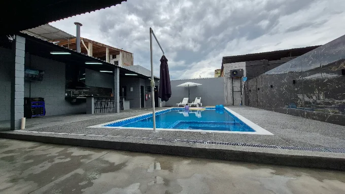Visão geral da área externa com piscina e área coberta