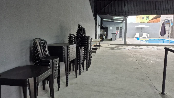Mesas e cadeiras disponíveis na área coberta