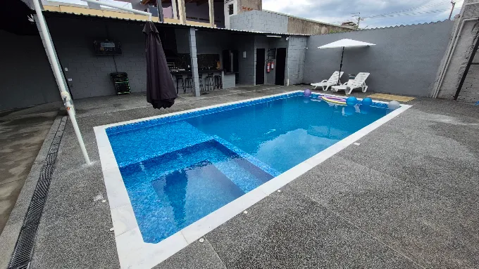 Piscina aquecida com área de descanso e espreguiçadeiras